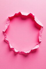 A Circular Frame Created by a Ripped Piece of Pink Paper on a Pink Background