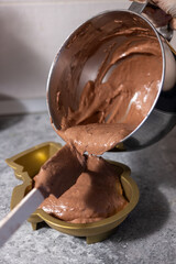 Woman pours cocoa cream in a snowman shaped bowl. Cooking for Christmas dinner party.