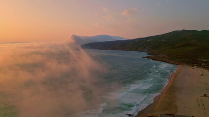 Serene ocean dawn aerial shot. Soft fog covering calm ocean surface at morning. 
