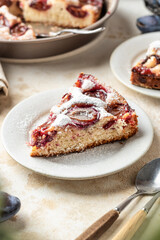 Homemade The New York Times plum cake. Slice of autumn fruit pie in a plate on beige textured background. Home cooking, recipe