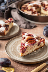 Homemade The New York Times plum cake. Slice of autumn fruit pie in a plate on brown background. Home cooking, recipe