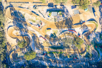 Drone aerial photograph of the Penrith Mini Bike Club speedway dirt track surrounded by trees and bushland in the greater Penrith region of NSW, Australia.