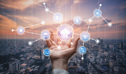 A hand reaches towards floating digital icons symbolizing cloud technology and connectivity, set against a stunning sunset over a bustling cityscape. Tessel