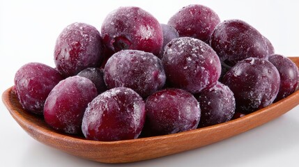 Fresh plums in a wooden bowl displaying natural frozen texture and color contrast