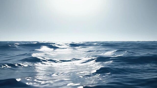 Waves gently rolling under a bright sun over a calm ocean surface at midday