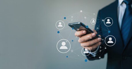 Connecting with the Network: A professional, expertly dressed in a suit, navigates a smartphone, illustrating the concepts of online connection and collaboration.