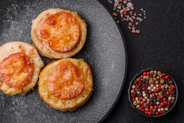 Round fish or chicken cutlets baked with tomato and cheese. Fish cutlets