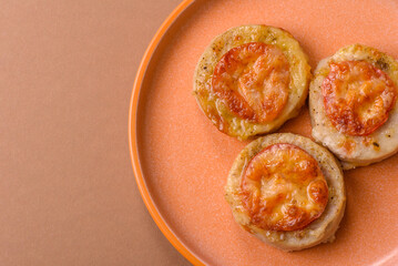 Round fish or chicken cutlets baked with tomato and cheese. Fish cutlets