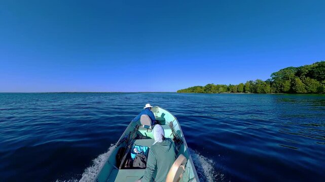 Man driving bass boat while woman seating at the front. Power sport, outboard fishing boat, with two people. Man and woman boating during fishing on the small v-hull boat.