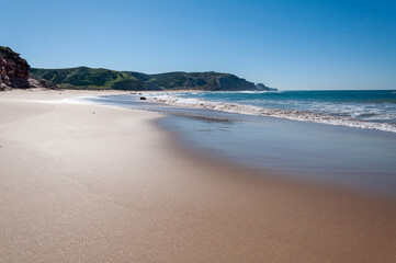 Praia do Amado, Algarve, Portugal.  The blue sky and calm water disguise the often wild and windswept Atlantic west coast of Portugal