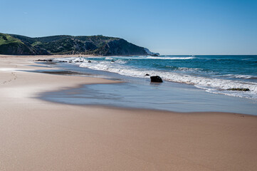 Praia do Amado, Algarve, Portugal.  The blue sky and calm water disguise the often wild and windswept Atlantic west coast of Portugal