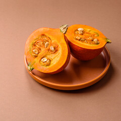 Half a raw pumpkin, a ripe orange colored butternut squash. Raw pumpkin