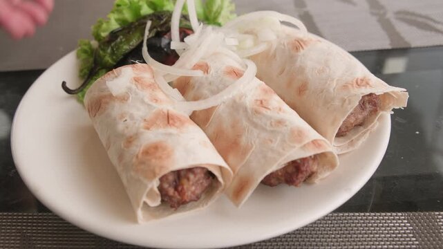 Serving lula kebab in pita bread on plate close-up