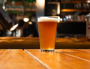 photo realistic full craft beer glass mockup on pub table with blurred pub in the background