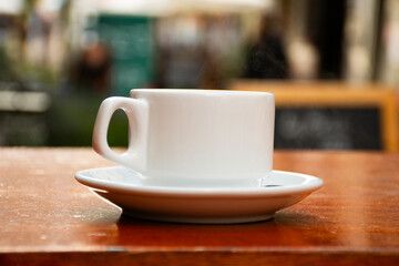 Editable photographic mockup of coffee shop brand logo on cup on sidewalk FRONT