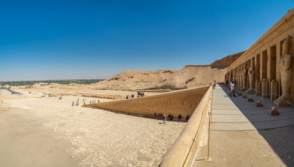 LUXOR, EGYPT : The Mortuary Temple of Hatshepsut at Valley of the Queens, an impressive ancient Egyptian monument built into limestone cliffs, visited by travelers from around the world.