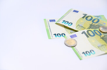 Euro banknotes and coins arranged on a white background with copy space. Minimal concept symbolizing finance, savings, banking, and European economy.