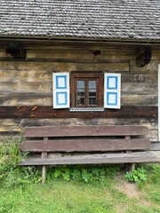 Casa de madeira antiga com banco de madeira e janela pintada em Museu na cidade de Olsztynek na Polonia