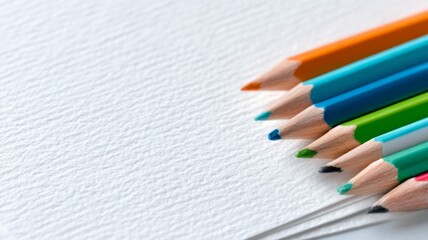 Obraz premium Macro shot of sharpened colored pencils placed on white textured paper, symbolizing creativity and education