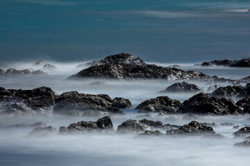 A fantastic ocean landscape with waves shaking on rocky areas