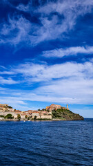 Fototapeta premium View from the sea to the ancient Mediterranean Italian old town Portoferraio on Elba Island in Tuscany. Vertical format.