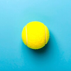 Single tennis ball on bright blue background