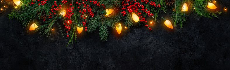 Festive Christmas garland with glowing light bulb