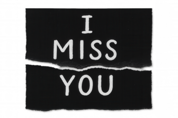 Torn black paper displaying i miss you message, symbolizing longing, separation, distance, and heartbreak