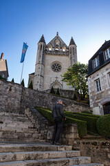 A man climbs the stairs to go to church in the town of Terrasson in the Dordogne region of France