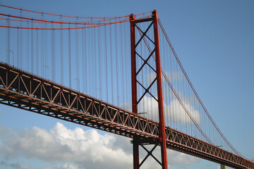 Red Suspension Bridge april 25 in lisbon Crossing Over Water Under Clear Sky, Iconic Steel Cable Structure