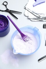 Hair care product for blonde hair and hairdresser's tools on white background, flat lay