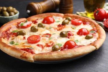 Delicious pizza with cheese, tomatoes and olives on dark grey table, closeup
