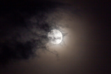 Full moon in the night sky with clouds