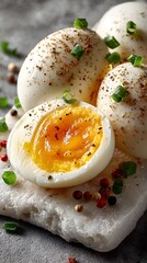 Freshly boiled eggs, perfectly halved with a runny yolk and topped with cracked pepper and chives, sit invitingly on a rustic marble serving platter.