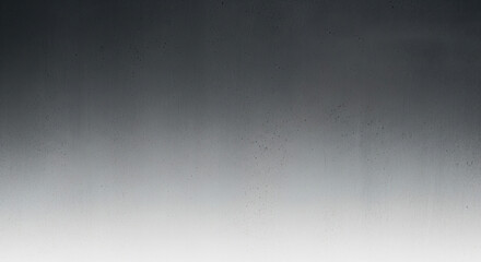 Fototapeta premium A metallic surface with a gradient from dark to light grey, featuring a few small, scattered specks of dirt or dust.