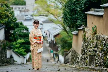 Fototapeta premium 石畳の坂道を歩く着物姿の女性