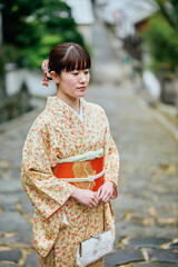 石畳の坂道を歩く着物姿の女性