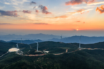 Wind power generation and windmills on a mountain at sunset.