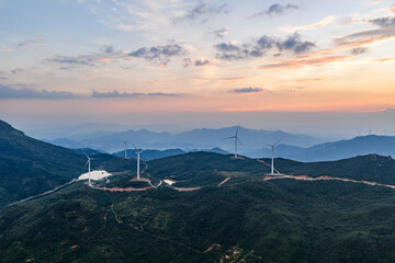 Wind power generation and windmills on a mountain at sunset.
