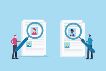 Two recruiters examining resumes and candidate profiles with magnifying glasses for hiring and recruitment process
