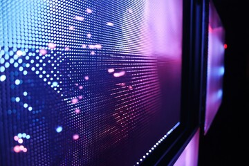 Close up view of a large led display screen showing blue and purple lights in a dark environment