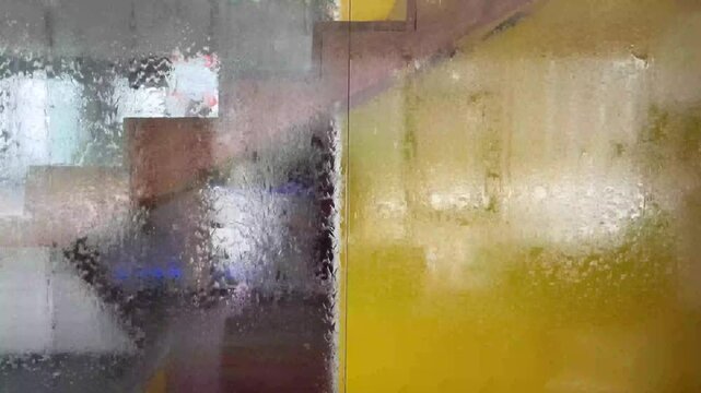 water flowing down on a glass panel creating a dis