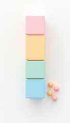 Pastel colored cubes stacked vertically with spheres arranged at the base on a simple white background