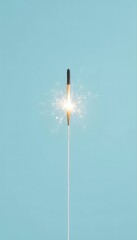 Sparkling Celebratory Light Emission Emanating from a Handheld Firework Set Against a Light Blue Background