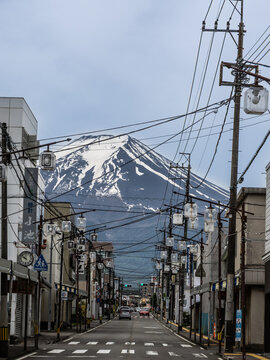 View of Mount Fuji from popular Honcho street within Fujiyoshida city with electric wires and poles criss cross the street.