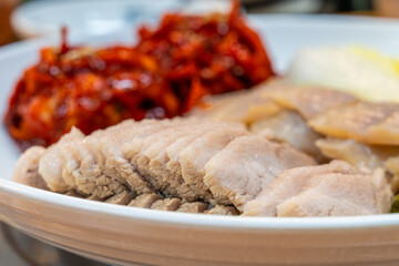 View of Samhap Cuisine composed of boiled pork, fermented skate, spicy radish kimchi and napa cabbage kimchi