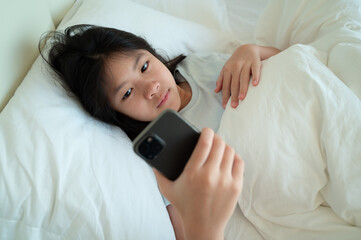 kid watching tablet on the bed, child addicted cartoon
