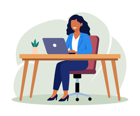 businesswoman working  on a laptop at an office desk or table