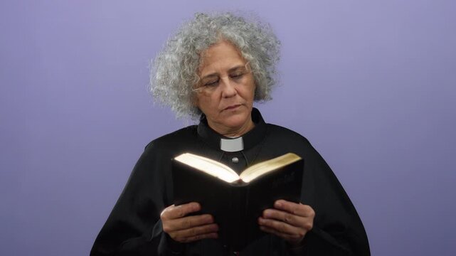 Elderly woman with grey hair reading a book against a purple background, wearing a black clergy outfit, evoking a sense of contemplation and spirituality