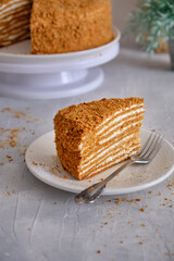 Honey cake on a white plate on a gray table